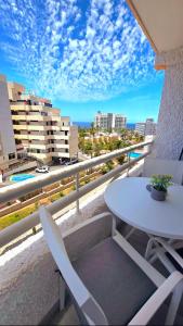 Una mesa y sillas en un balcón con vista a la ciudad. en 524 Ocean Dreams Las Americas, en Playa de las Américas