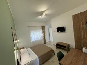 a hotel room with a bed and a table at Philia Rooms in Leporano Marina
