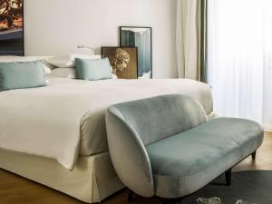a bedroom with a large bed and a chair at Sofitel Roma Villa Borghese in Rome