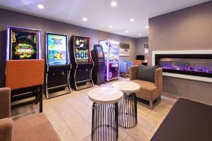 a room with two arcade games and two tables and chairs at La Quinta Inn by Wyndham Sheboygan in Sheboygan