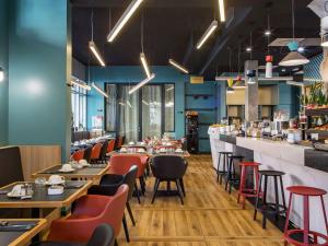 ein Restaurant mit Tischen und Stühlen und einer Bar in der Unterkunft Mercure Paris Saint-Ouen in Saint-Ouen