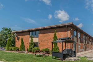 a brick building with a bench and an umbrella at Comfort Inn Cobourg in Cobourg