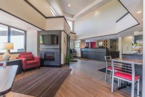 a living room with a red chair and a fireplace at Comfort Inn Cobourg in Cobourg