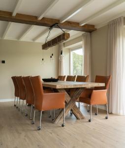 a dining room with a wooden table and chairs at Familiehuis Het Gouden Plekje in Heeten