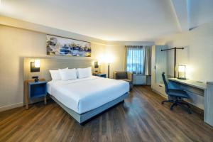 a hotel room with a large bed and a desk at Comfort Inn Magnetic Hill in Moncton