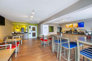 ein Restaurant mit Bar sowie Tischen und Stühlen in der Unterkunft Comfort Inn Magnetic Hill in Moncton