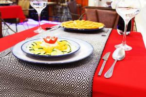 a table with a plate of food on a red table at Ikaze B&B in Kigali