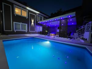 a swimming pool in front of a house at night at Vila CITY by BEN&CO in Sarajevo