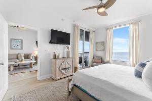 a white bedroom with a bed and a large window at Spanish Key 603 in Perdido Key
