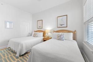 two beds in a room with white walls at Spanish Key 603 in Perdido Key +36 photos