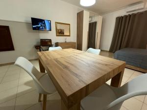 a living room with a wooden table and white chairs at ZIO PEPPE in Senise