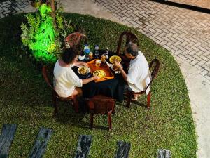 a group of men sitting at a table eating food at Jaya Villa - Near Airport in Negombo