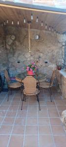 a patio with a table and chairs and a stone wall at Casas Rurales el Olmo in Riópar Viejo