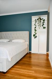 a bedroom with a white bed and a blue wall at Melton Home Stay in Melton