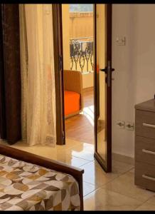 BouzareahにあるRésidence la villaのバルコニーに通じるガラスの引き戸のある寝室