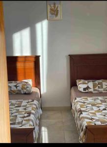 BouzareahにあるRésidence la villaの部屋に並んで置かれた2つのベッド +2枚の写真