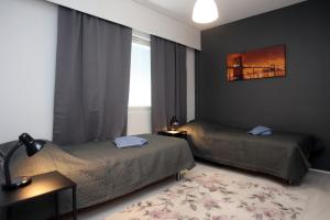 a bedroom with two beds and a window at Kolmio Kokkola in Kokkola