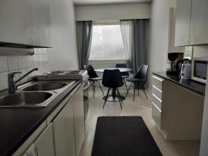a kitchen with a sink and a table with chairs at Kolmio Kokkola in Kokkola +7 photos