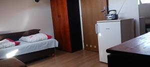 a small room with a refrigerator and a bed at Central apartman in Nivy