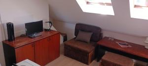 a room with a desk and a chair and a television at Central apartman in Nivy