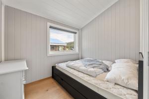 a bed in a room with a window at Felehovet Nord 99 in Gautefall