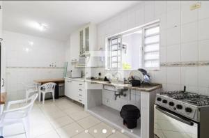 a white kitchen with a sink and a stove at LPJ HOMEs3 in Sao Paulo
