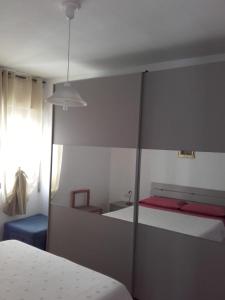 a bedroom with a bed and a mirrored wall at Casa Pina in Cala Gonone