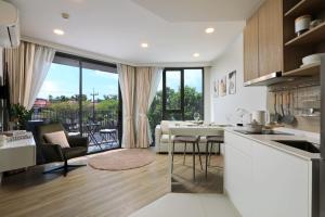 a kitchen and living room with a view of a patio at Sky Park condo 1 bedroom in Laguna Phuket