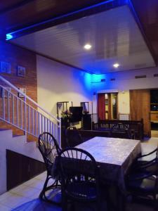 a room with a table and chairs and a staircase at Villa Pandawa tawangmangu in Tawangmangu