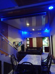 a table and chairs in a room with blue lights at Villa Pandawa tawangmangu in Tawangmangu