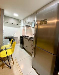 a kitchen with a stainless steel refrigerator and a table at Seu cantinho in Sao Paulo