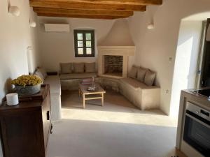 a living room with a couch and a fireplace at Elegantly restored traditional cottage in Logothetiánika +27 photos