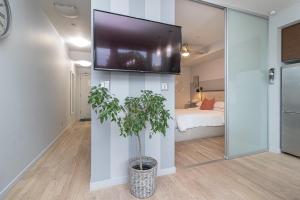 a room with a tv on a wall with a plant at Sleek Kitchen Island And Garden Views in Victoria