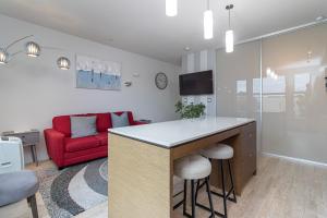 a kitchen and living room with a red couch at Sleek Kitchen Island And Garden Views in Victoria