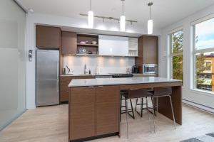 a kitchen with a large island with bar stools at Sleek Kitchen Island And Garden Views in Victoria