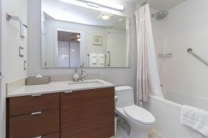 a bathroom with a sink and a toilet and a mirror at Sleek Kitchen Island And Garden Views in Victoria +20 photos