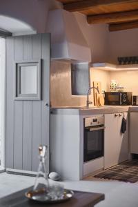a kitchen with a sink and a counter top at Elegantly restored traditional cottage in Logothetiánika