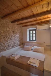 a bed in a room with a wooden ceiling at Elegantly restored traditional cottage in Logothetiánika