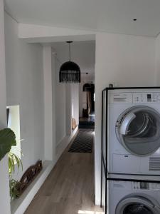 a washer and dryer in a room with a hallway at White Door Apartments Mansard Heart of Odessa 2 in Odesa
