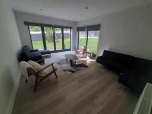a living room with a black couch and chairs at Gorey Private Lodging & Holiday Mansion in Hollyfort