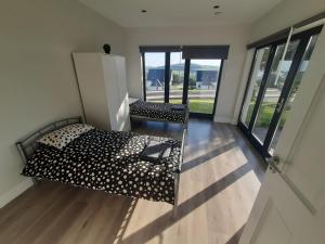 a bedroom with a bed and a chair in a room with windows at Gorey Private Lodging & Holiday Mansion in Hollyfort