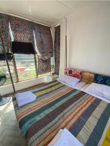 a bedroom with a large bed and a window at Popbeachclub Suites ilashe in Ibasa
