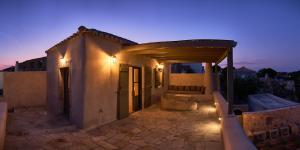 a house with a patio at night with lights at Elegantly restored traditional cottage in Logothetiánika