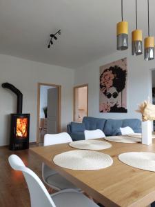 a dining room with a table and a blue couch at Hunor Vendégház in Golop