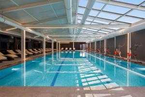 a large swimming pool in a large building at Batumi Luxury Panoramic Sea View Apartment in Angisa