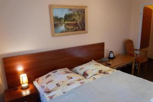 a bedroom with a bed with a wooden headboard and a table at OW Patryn in Karpacz