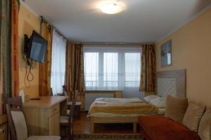 a room with two beds and a desk and a television at OW Patryn in Karpacz