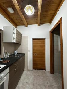 a kitchen with wooden ceilings and a wooden door at Casa Dafne di Palazzo Biondi in Giarre +5 photos