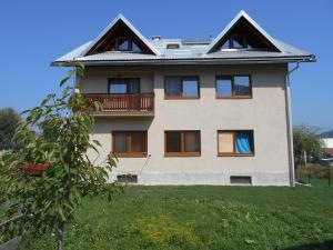 a house with a balcony on top of a yard at Apartments T&M in Mrkopalj