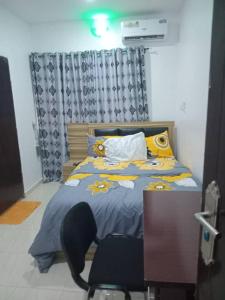 une chambre avec un lit et un bureau avec une chaise dans l'établissement Molayo Luxury Apartment Omolayo Estates Akobo Ojurin Ibadan, à Ibadan